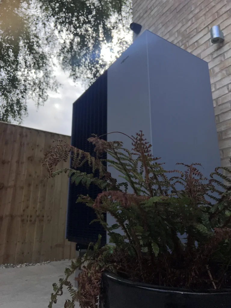 Air source heat pump installed beside a residential property